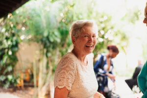 Beautiful older woman smiling in an off-white sparkle dress 